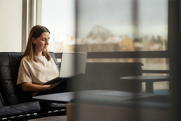 En tjej med en dator på kontoret