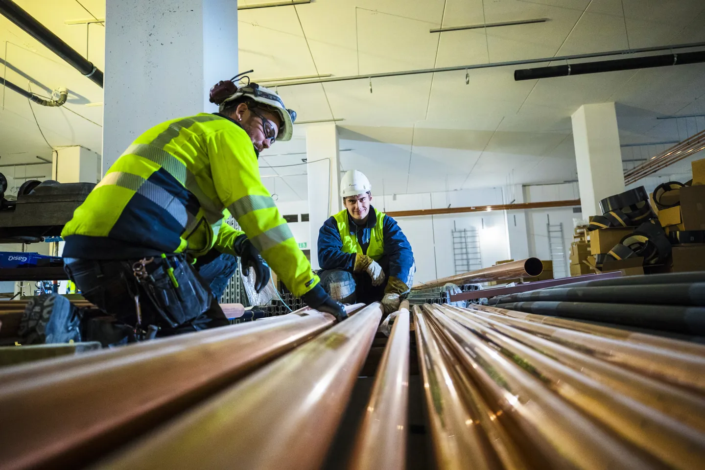 VVS-montører inspicerer kobberrør på en byggeplads i København