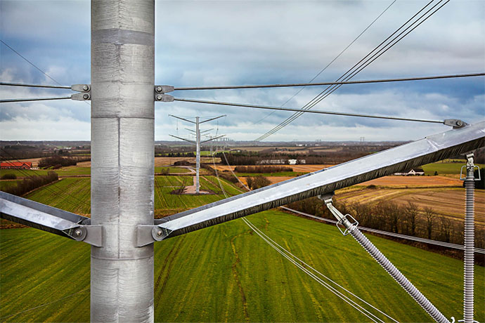  Power line with electricity poles and high voltage wires over agricultural landscape.