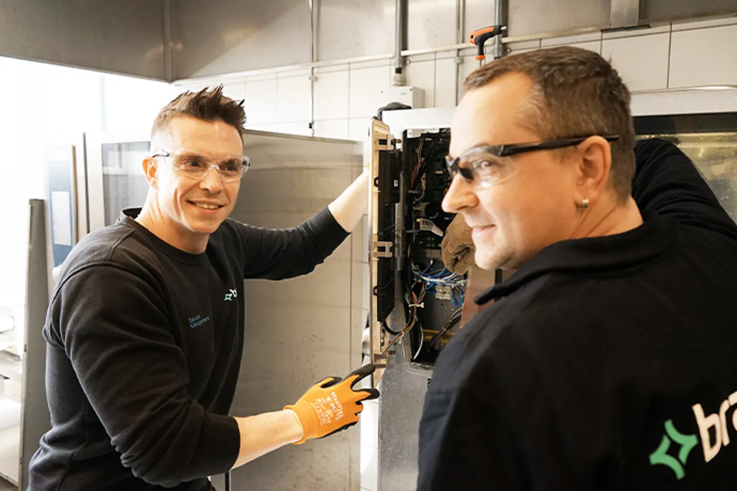 Två tekniker som gör service och installation i storköksmiljö