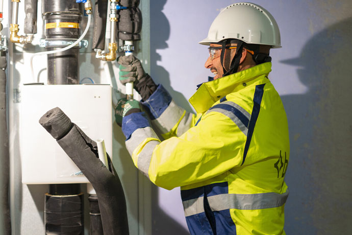 A plumber/plumbing technician doing a pipe installation