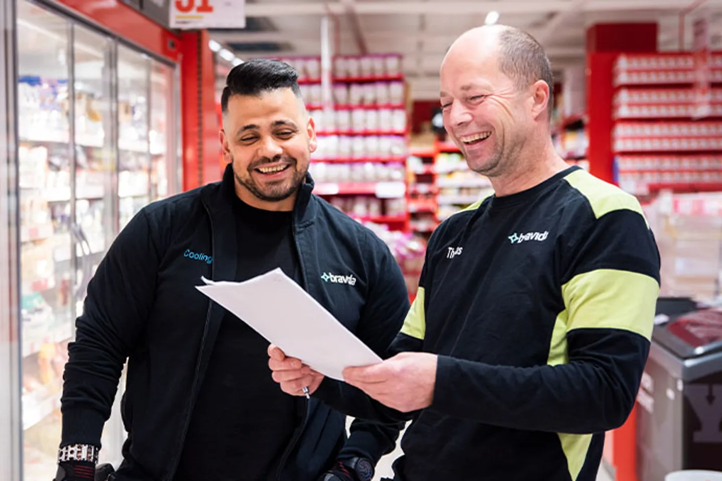 Två kyltekniker under ett samtal i butiksmiljö